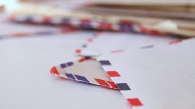 Posta zarfları yığını, açık zarflar birbirinin üstüne serilmiş, temizlenmiş ve hafızası silinmiş, odak arkaplanı dışında.