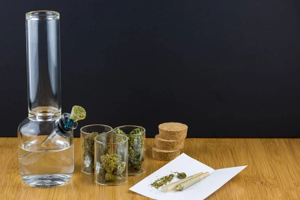 玻璃器皿旁边的医用大麻锥形滚动纸和接头 — 图库照片