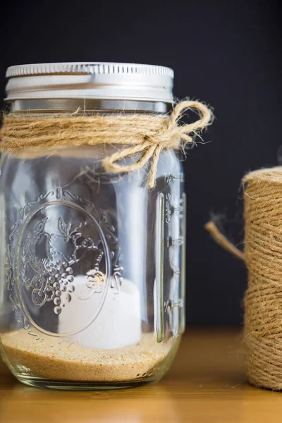 Decorative glass jar with twine spool — Stock Photo, Image