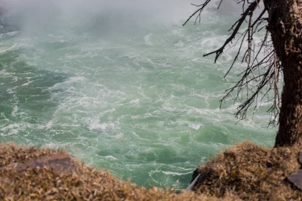 Rough water raging under cliff in spring — Stock Photo, Image