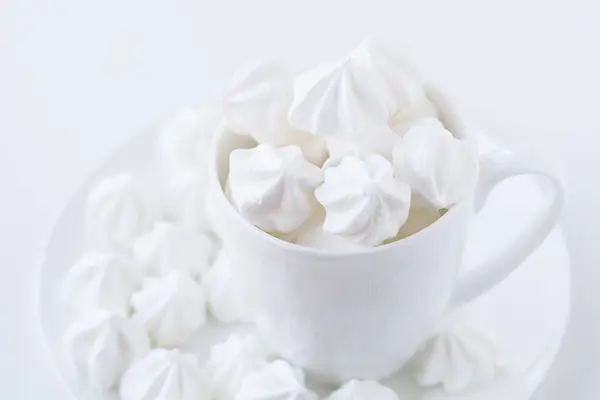 O merengue branco na xícara de chá branco no fundo branco — Fotografia de Stock