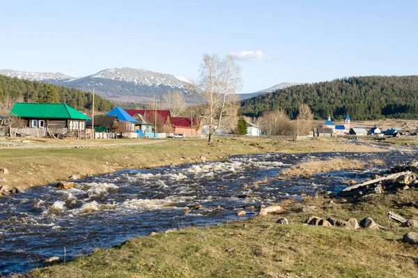 Un río de montaña fluye junto al pueblo — Foto de Stock