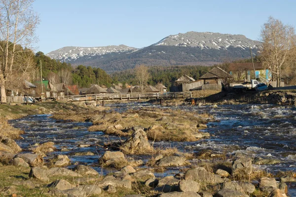 Un río de montaña fluye junto al pueblo — Foto de Stock