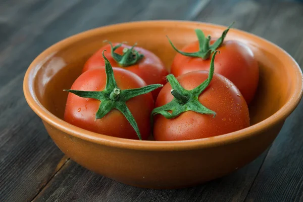 Ahşap bir masa üzerinde sulu olgun domates