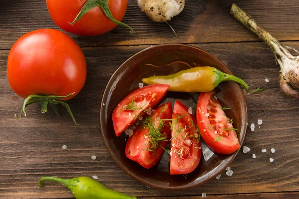 Ripe sliced tomatoes, hot chili peppers, garlic on a wooden tabl — Stock Photo, Image