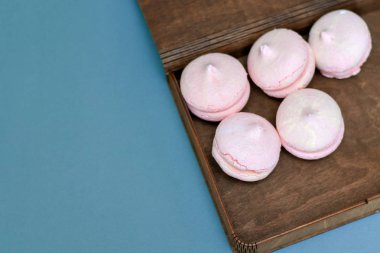 mavi bir arka plan üzerinde kahverengi bir kutu içinde pembe tatlı yalan