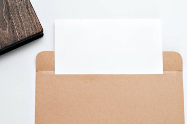 bir mektup ve bir ahşap kitap ile kahverengi zarf