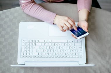 bir telefon ve bir dizüstü bilgisayar yakın elinde