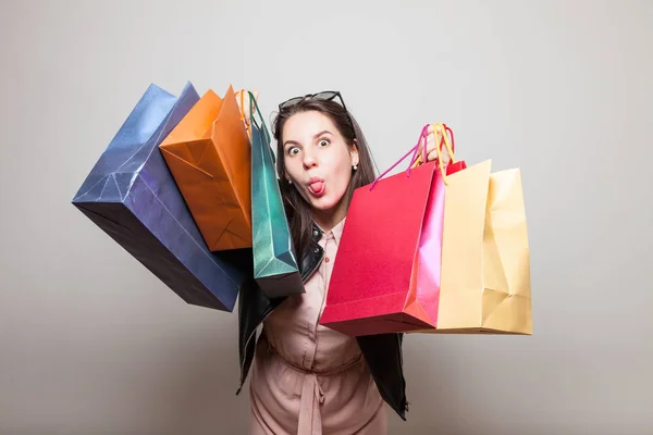 Menina Louca Mostra Língua Com Sacos Presente Compras Nas Mãos — Fotografia de Stock