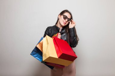 Gülümseyen genç kız hediye çantaları tutar