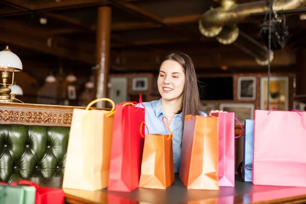 Wunderschöne Brünette Frau Sitzt Einem Bistro Mit Vielen Bunten Geschenktüten — Stockfoto