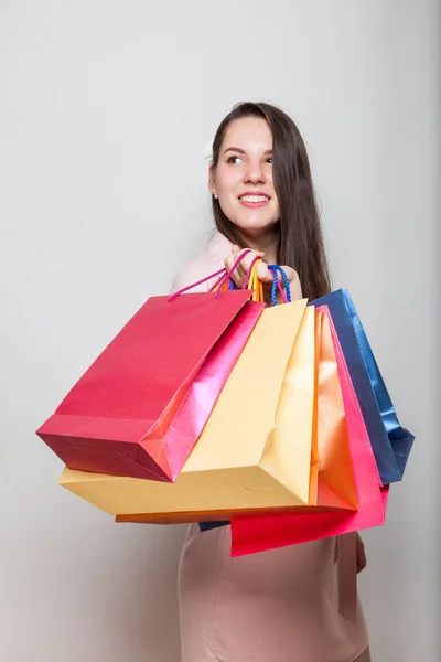 幸せな笑みを浮かべて少女は休日のブラックフラ イデー セールでの買い物袋を持って立っています — ストック写真