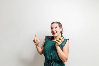 Sevimli genç kız meyve yeme gülümser ve köşe noktalarına