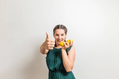 Zarif fitness eğitmeni başparmak yukarıya için meyve limon ile vitamin tam odakta gösterir.