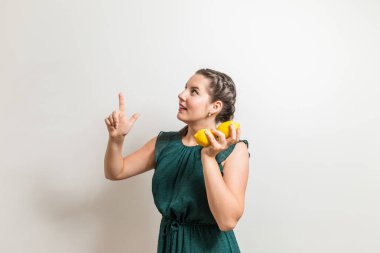 Kız bir işareti ayakta beyaz arka plan üzerinde meyve ile işaret