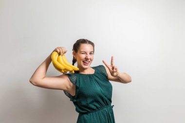 Sıcak öğrenci kız winks ve muz meyve sunar