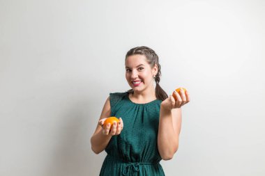 Güzel görünümlü kız turuncu elinde tutar.