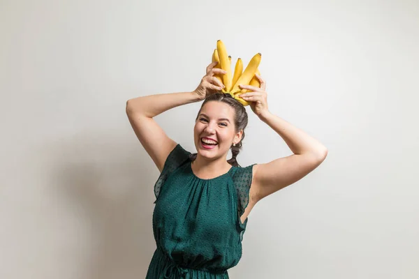 Riéndose adolescente pone plátanos en una cabeza Imagen de archivo