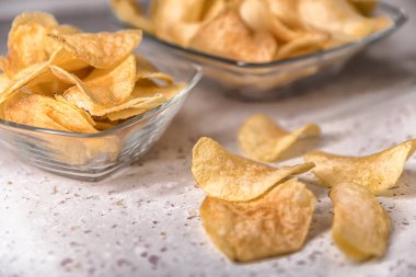 beyaz zemin üzerine bir tabak patates cipsi