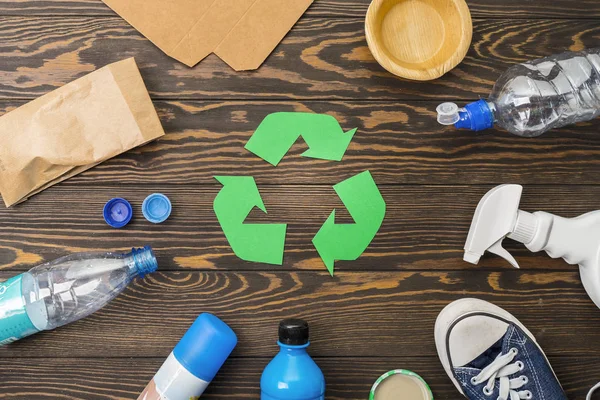 waste recycling eco symbol with garbage disposal on wooden table background top view