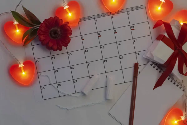 Defter, pamuk tampon, kırmızı çiçek ile adet takvim. Kadın kritik gün, kadın hijyen koruma