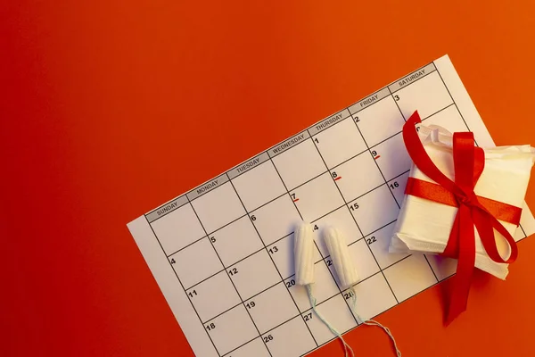 Defter, pamuk tampon, kırmızı çiçek ile adet takvim. Kadın kritik gün, kadın hijyen koruma
