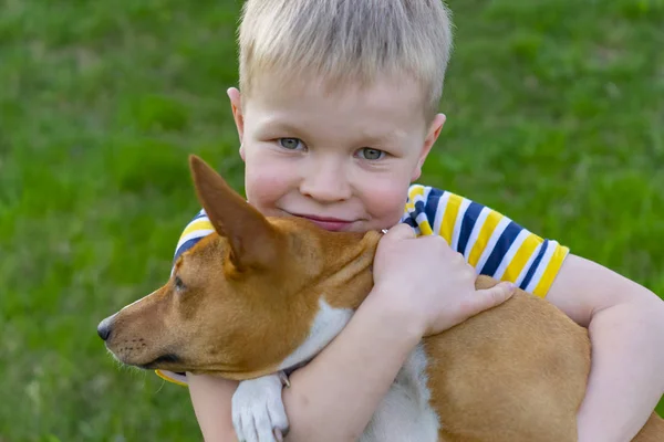 neşeli çocuk sarılma bir köpek, bir kavramı mutlu çocukluk ve dostluk