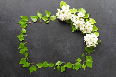 Siyah desenli arka planda beyaz çiçekli yeşil bahar yaprakları.