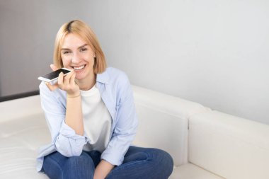 Kadın telefon görüşmelerini hoparlörden yapıyor, ses tanıma ya da internet hizmetlerini sanal asistan aracılığıyla kullanıyor, sesli mesaj kaydediyor. Boşluğu kopyala