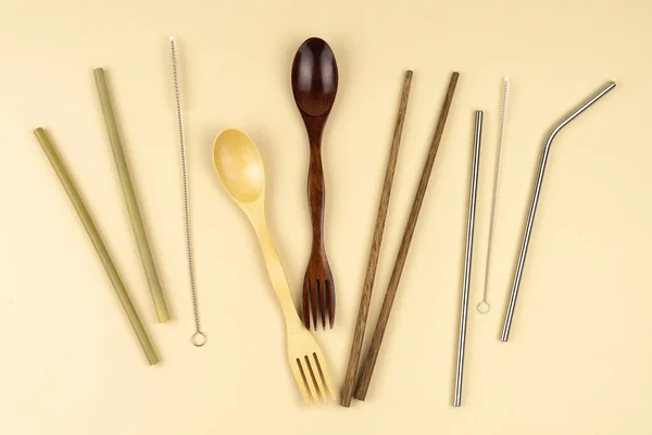 Eco food items. Wooden spoon and fork. Iron tubules for drinks with brushes for cleaning.