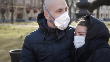 Arkadaşlar, birbirini seven bir erkek ve bir kız, evde kalma tavsiyelerine rağmen, kişisel tecrit sırasında bir bankta oturur ve maske ve solunum cihazıyla iletişim kurarlar.