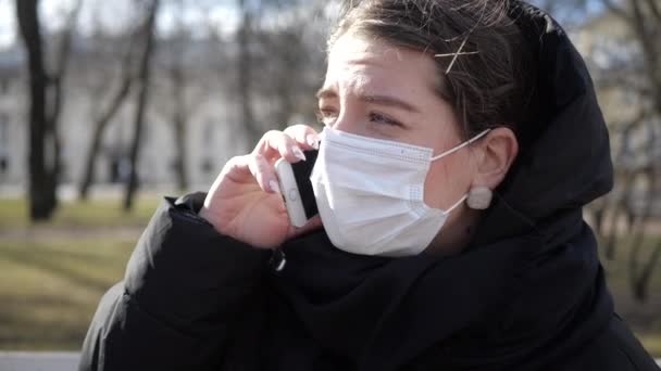 Ένα Κορίτσι Μαύρο Μπουφάν Και Ιατρική Μάσκα Μιλάει Δυνατά Στο — Αρχείο Βίντεο