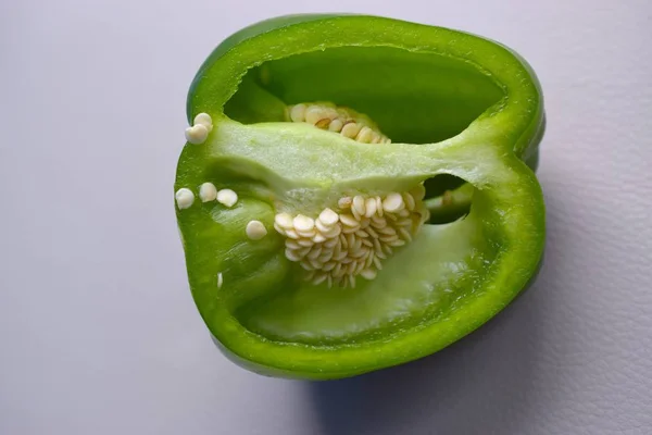 Organic green pepper with seeds cut close up shot.