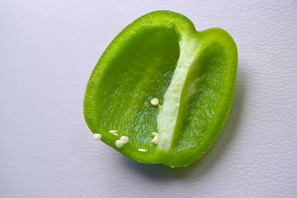 Organic green pepper with seeds cut  close up on light background.