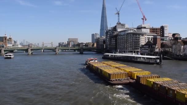 짐을 실은 배가 런던 중심부에 있는 템스강을 따라 흐른다. — 비디오
