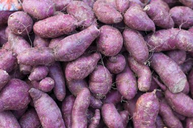 Yakın çekim tatlı patates mor soyma yam ham birçok Pazar arka planda