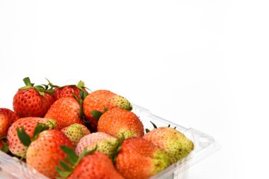 Olgun kırmızı çilek izole beyaz arka plan, alan yazma kopyası, çilek ananassa plastik şeffaflık paketindeki yakınındaki yakın çekim