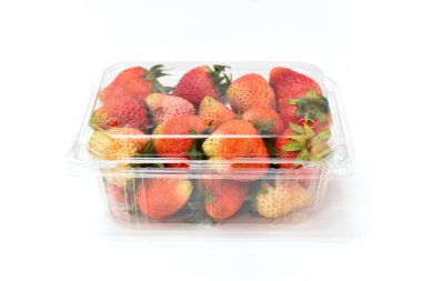 Olgun kırmızı çilek beyaz arka plan üzerinde çilek ananassa izole plastik şeffaflık paketindeki yakınında kapatın