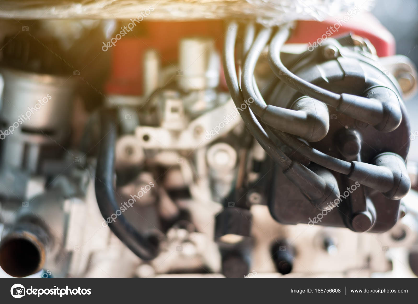Close up coil distributor wire four cylinder engine stand on car with sunlight — Photo by superfroydclub@gmail.com
