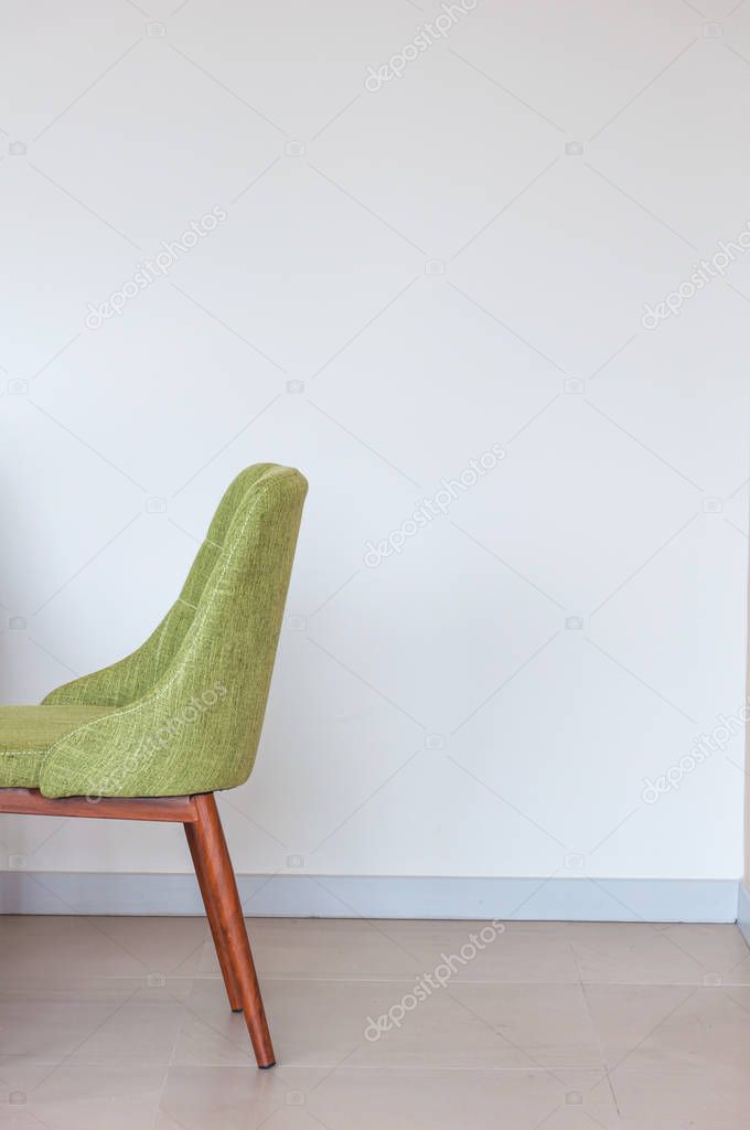 Close up green chair modern style on white concrete corner background 