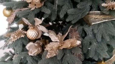 Toplarla, çiçeklerle, hediyeliklerle ve oyuncaklarla süslenmiş Noel ağacı.