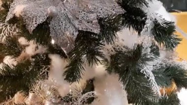 Parlak çelenkleri, süslemeleri ve çerçevesinde ışık olan sarı bir arabası olan Noel ağaçları.