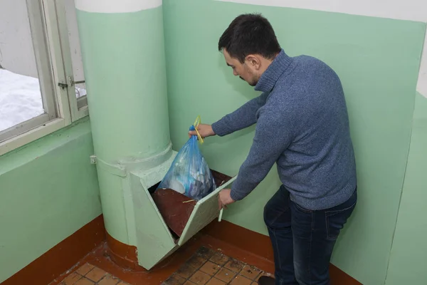 Throwing out garbage Packed in a garbage bag using a home trash chute in Russia