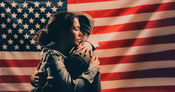 独立日 纪念日 一个女人拥抱一个士兵以美国国旗为背景的一对夫妇 复制空间 美国国定假日和爱国主义的概念 — 图库照片