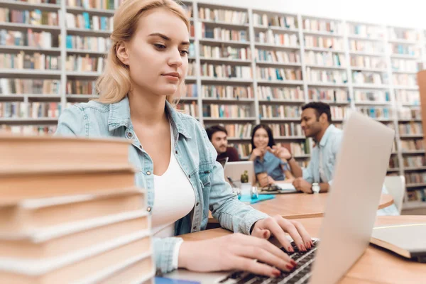 一群多文化的学生坐在图书馆的桌子上 白人女孩在笔记本电脑上工作 — 图库照片