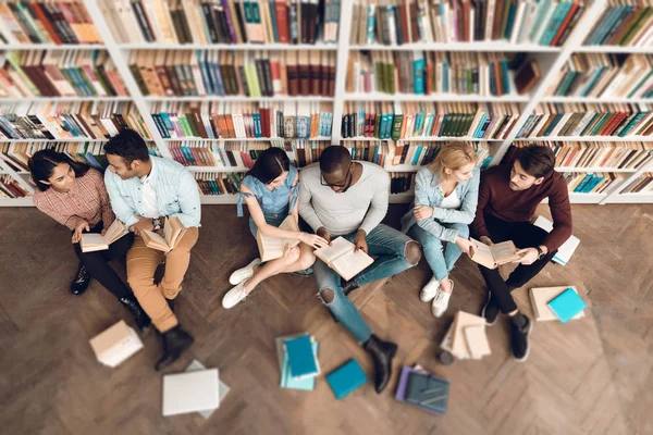 Группа Этнических Мультикультурных Студентов Сидящих Возле Книжных Полок Библиотеке — стоковое фото