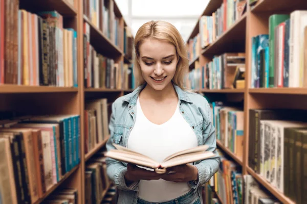 Χαμογελώντας Λευκό Κορίτσι Ανάγνωση Βιβλίων Στη Βιβλιοθήκη — Φωτογραφία Αρχείου