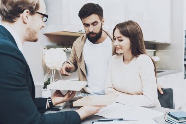 Çift istemcilerine mutfak mağazasında farklı malzeme gösterilen takım yöneticisi