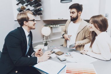 Çift istemcilerine mutfak mağazasında farklı malzeme gösterilen takım yöneticisi