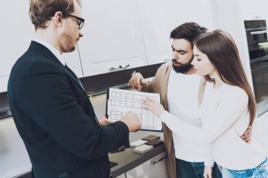 Mutfak mağazasında çift istemcilere planları gösterilen takım yöneticisi